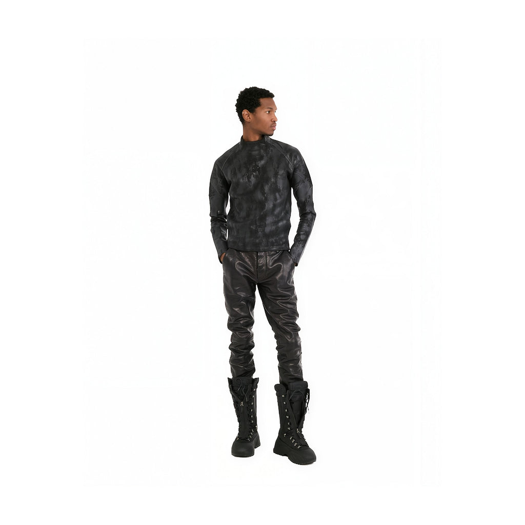 A man modeling a black textured leather or faux-leather long-sleeve top and matching pants with black lace-up boots, shown against a plain white background.