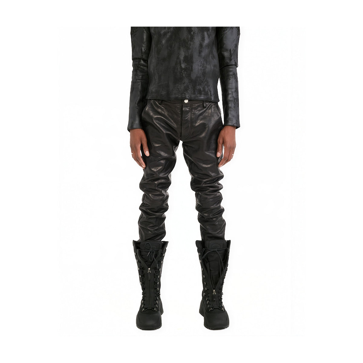 A model shown from the chest down wearing black textured leather pants, a matching black textured long-sleeve top, and black lace-up combat boots, set against a plain white background.